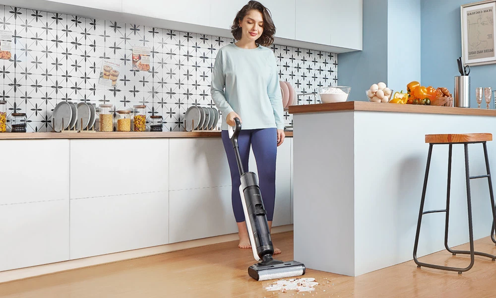 Ultenic AC1 Elite a woman using a vacuum cleaner in a kitchen